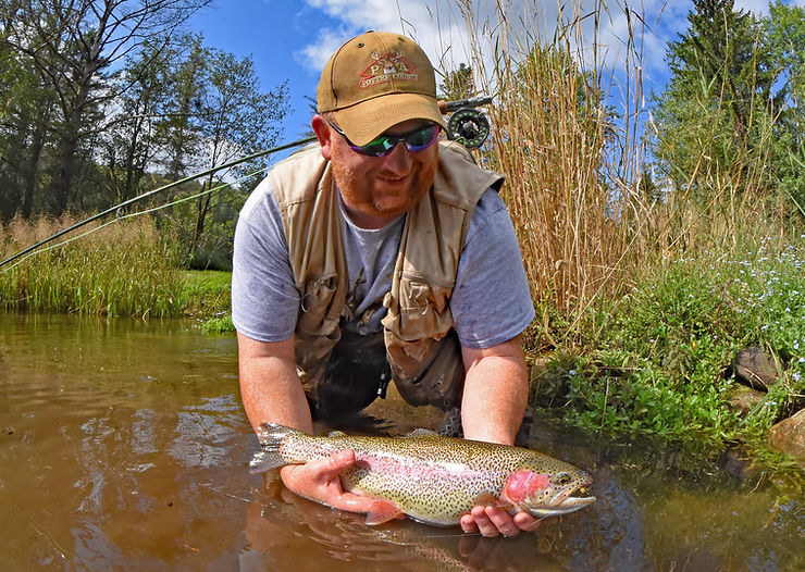 Ralph holding a large rainbow trout after hooking and landing it