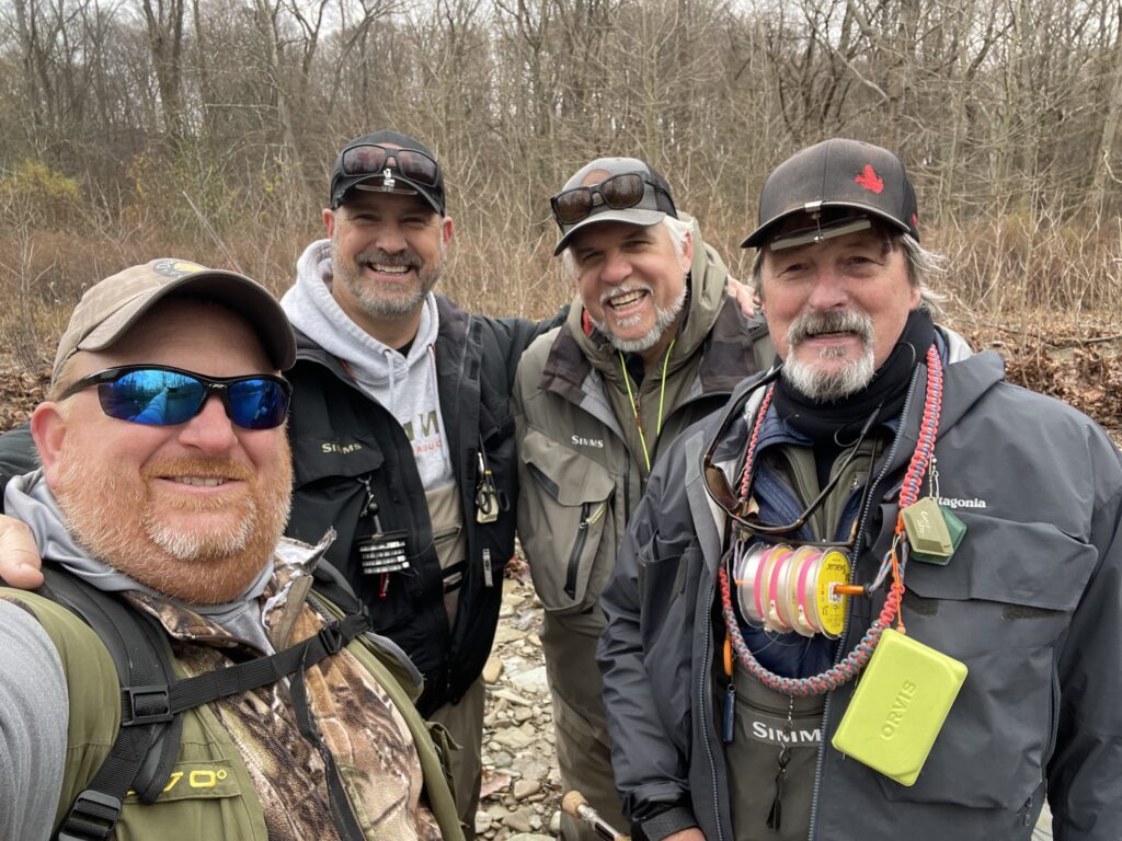 group of guys standing by a stream