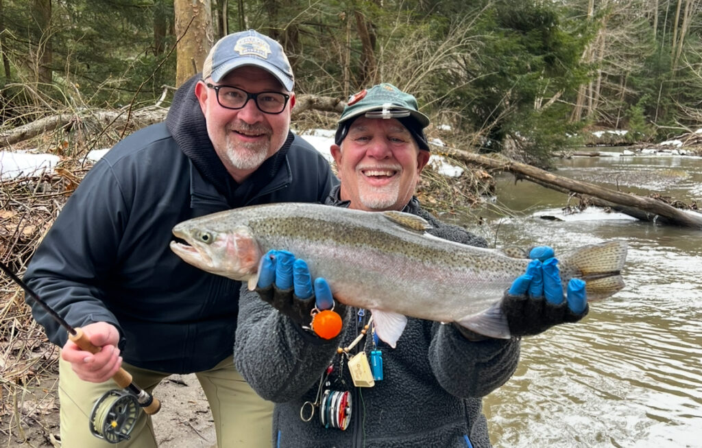 two guys holding a steelhead