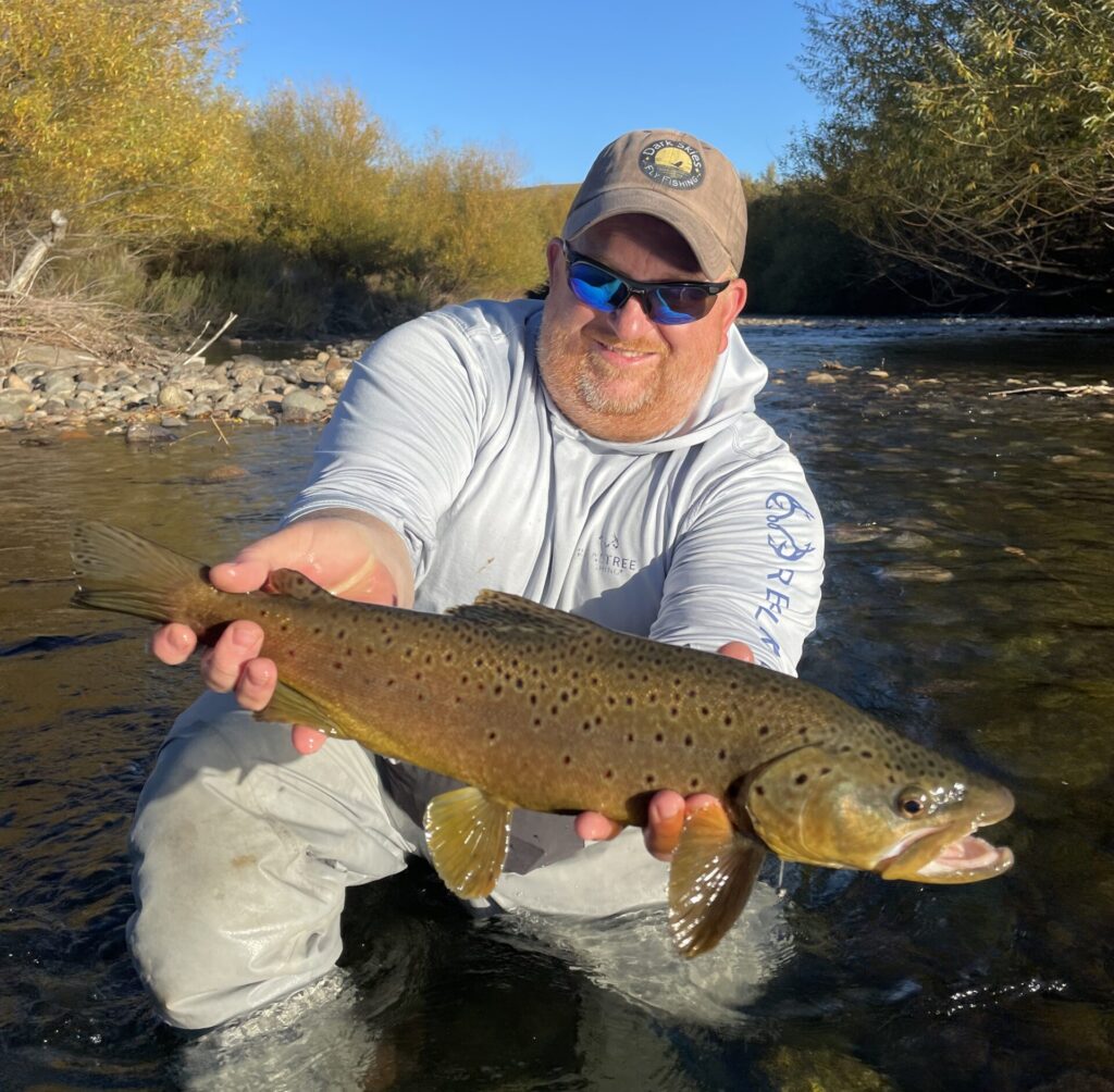 man holding fish in a river