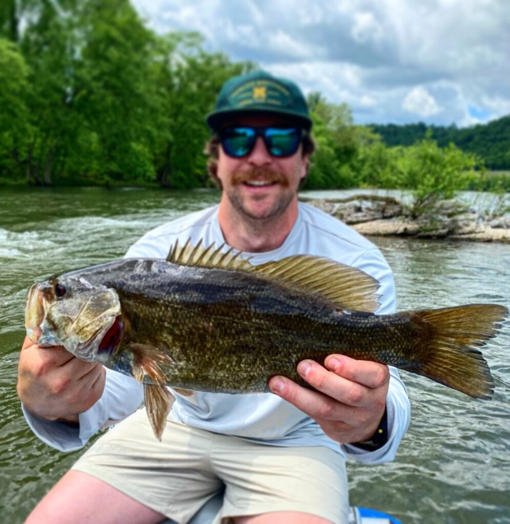 post spawn smallmouth bass with man by river